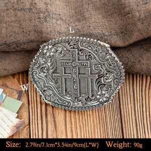 May include: Silver-colored belt buckle with three crosses in the center, surrounded by floral and scrollwork designs. The buckle measures 2.79 inches by 3.54 inches. The weight is 90 grams.