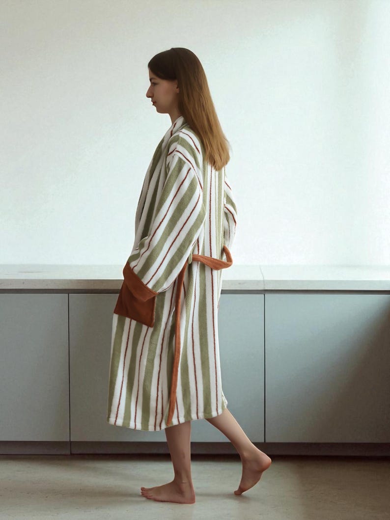 May include: A striped robe in shades of green, white, and burgundy. The robe features a brown pocket and a matching belt. The robe is made of a soft, absorbent material, perfect for after a shower or a relaxing day at home.