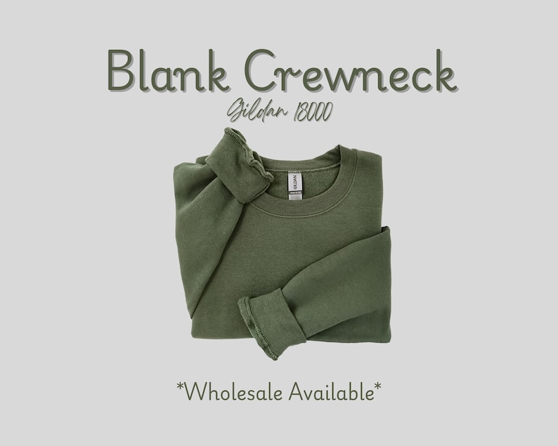 May include: An olive green blank crewneck sweatshirt, folded neatly. The text "Blank Crewneck" and "Gildan 18000" are displayed above the sweatshirt. The words "Wholesale Available" are at the bottom.