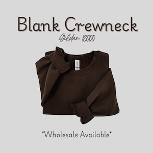 May include: A dark brown blank crewneck sweatshirt, folded neatly. The text "Blank Crewneck" is above the sweatshirt, with "Gildan 18000" below it. The words "Wholesale Available" are at the bottom of the image.