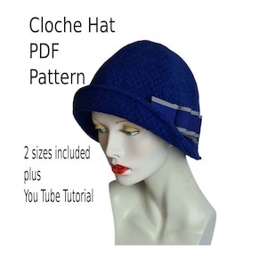 Puede incluir: Un sombrero cloche azul con una cinta gris y azul. El sombrero está en una cabeza de maniquí blanca. El texto "Cloche Hat PDF Pattern" está por encima del sombrero. El texto "2 sizes included plus You Tube Tutorial" está por debajo del sombrero.