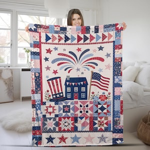 May include: A rectangular quilt featuring a patriotic theme with a central graphic of a top hat, a blue house, and an American flag beneath fireworks. The border consists of various red, white, and blue patchwork squares and star patterns.