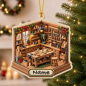May include: A hexagonal Christmas ornament featuring a detailed 3D-style illustration of a woodworking shop. The scene includes a workbench, tools, a stool, and festive greenery with red bows. A white plaque at the bottom displays the text Name.