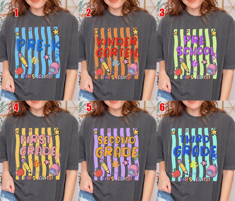 May include: Dark gray t-shirts with colorful grade level designs. Each shirt features a grade level like "Pre-K" or "Kindergarten" in a vertical striped design with school-themed graphics, including pencils, apples, and backpacks. The text "Mrs. Alice" is at the bottom.
