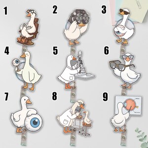 May include: A collection of nine badge reels featuring white cartoon geese in various optometry-themed roles. Each goose is depicted with medical equipment like eye charts, phoropters, glasses, and anatomical eye models, all attached to retractable clips.