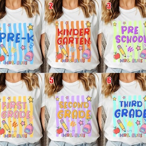 May include: White t-shirts with colorful graphics for different grade levels: Pre-K, Kindergarten, Preschool, First Grade, Second Grade, and Third Grade. Each design includes a pencil, apple, backpack, and the name "Mrs. Alice".