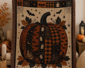May include: A woven throw blanket featuring a large central pumpkin design composed of various black and orange patterned panels including ghosts, bats, plaid, and haunted houses, surrounded by autumn leaves, spiderwebs, and stars on a cream background.