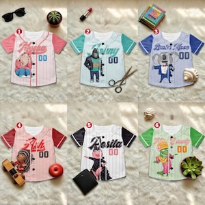 May include: Six baseball-style shirts with character graphics and names. Each shirt has a different color scheme, including pink, blue, and green. The shirts feature the names "Meena", "Johnny", "Buster Moon", "Ash", "Rosita", and "Miss Crawly" with the number "00".
