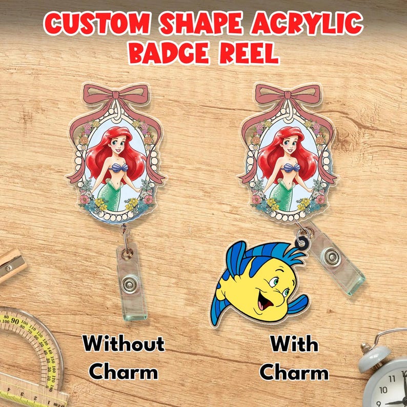 Puede incluir: Dos portatarjetas de acr&iacute;lico con forma personalizada que muestran una sirena pelirroja en un marco floral con un lazo rosa. Uno es simple, el otro incluye un dije de pez amarillo y azul. Texto: CUSTOM SHAPE ACRYLIC BADGE REEL, WITHOUT CHARM, WITH CHARM.