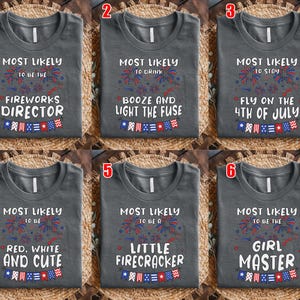 May include: Six gray t-shirts with patriotic designs. Each shirt has a different phrase, including "Fireworks Director," "Drink Booze," and "Fly on the 4th of July." The designs feature fireworks and American flag elements.