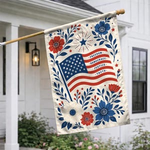 May include: A rectangular flag featuring the American flag with the words "Freedom, Democracy, Justice, Truth." The flag is decorated with red, white, and blue floral and leaf designs. The flag is hanging on a wooden pole.