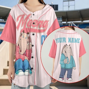 May include: A white and pink pinstriped baseball jersey featuring a button-down front. The front displays the name Meena in pink script above a graphic of an elephant character. The back shows the text YOUR NAME above an elephant illustration.