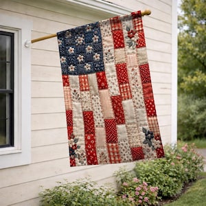 May include: A rectangular flag featuring a patchwork design in red, white, and blue fabric patterns. The flag displays a field of blue with white floral accents and vertical stripes composed of various floral and plaid textiles with 3D flower appliqués.