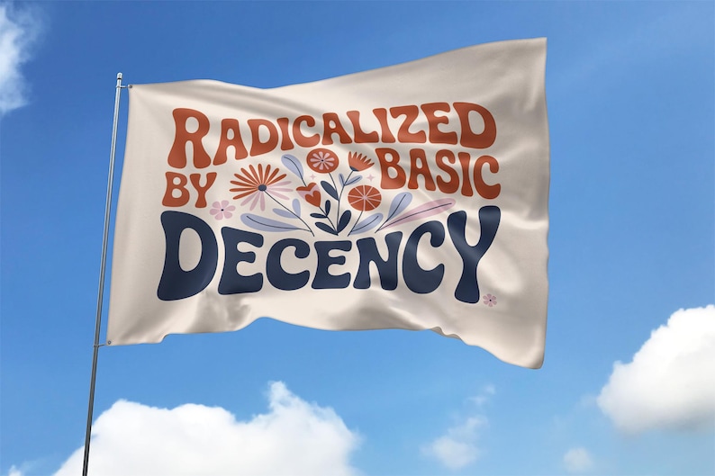 Może przedstawiać: Biała flaga powiewa na wietrze na tle błękitnego nieba. Flaga zawiera słowa "RADICALIZED BY BASIC DECENCY" w stylu retro, z kwiatowymi ilustracjami. Tekst jest w odcieniach pomarańczu i granatu.