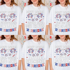 May include: White t-shirts with various patriotic phrases in red, white, and blue. Phrases include "Fireworks Director," "Booze and Light the Fuse," "Fly on the 4th of July," "Red, White, and Cute," "Little Firecracker," and "Girl Master."