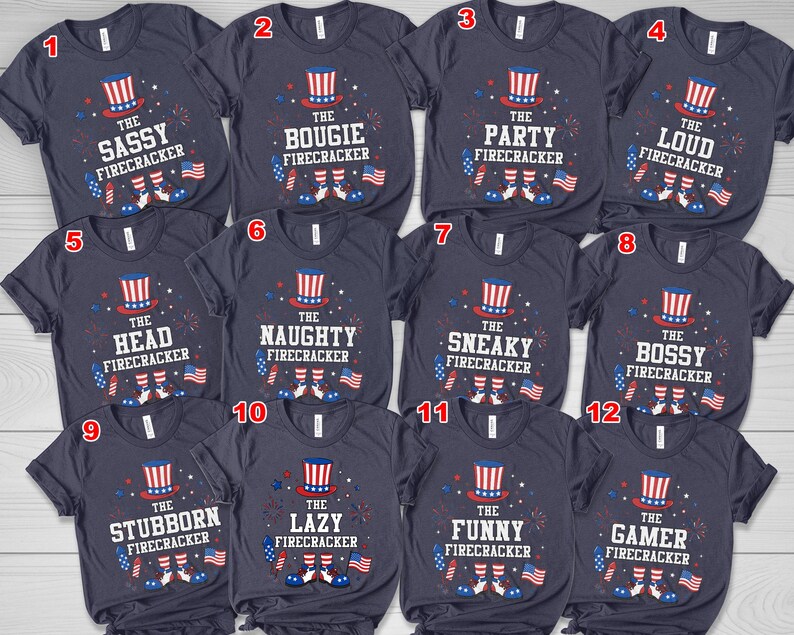 May include: Navy blue t-shirts with various phrases and graphics related to fireworks and the Fourth of July. Each shirt features a top hat, fireworks, and American flags. Phrases include "The Sassy Firecracker" and "The Bougie Firecracker."