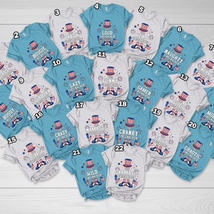 May include: A selection of baby and toddler t-shirts in various colours, each with a patriotic firecracker design and text. The shirts have short sleeves and are suitable for Independence Day celebrations.