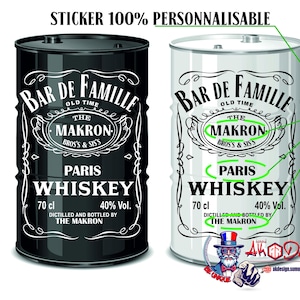 Peut inclure: Deux barils métalliques cylindriques, un noir et un blanc, avec des étiquettes personnalisées portant le texte BAR DE FAMILLE, THE MAKRON, PARIS WHISKEY, 70 cl, 40% Vol., et DICTILLED AND BOTTLED BY THE MAKRON. L'image inclut le texte STICKER 100% PERSONNALISABLE.