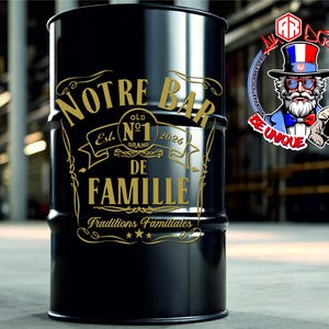 May include: A black cylindrical metal drum featuring gold-colored text that reads NOTRE BAR DE FAMILLE, with a central emblem displaying No 1, Est 2026, and the phrase Traditions Familiales at the bottom, accented by decorative scrollwork lines.