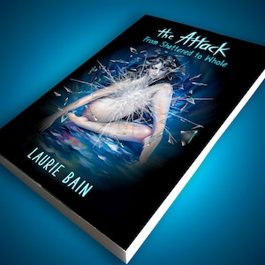 May include: A book titled The Attack: From Shattered to Whole by Laurie Bain. The cover features a black background with a central illustration of a figure surrounded by shards of glass, set against a blue, wavy, water-like base at the bottom.