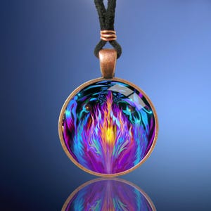May include: A round glass pendant necklace with a copper frame. The pendant features a colorful abstract design of flames in shades of blue, purple, and yellow.