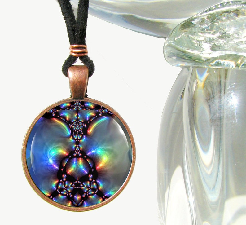 May include: A round copper pendant necklace with a colorful iridescent image inside. The image is abstract and features a swirling pattern of blues, purples, and greens.