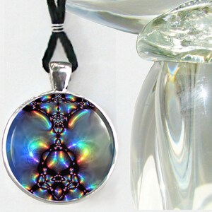 May include: A silver pendant necklace with a round, iridescent, blue and purple image of a fractal design. The necklace is on a black cord.