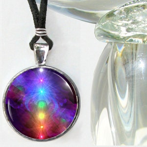 May include: A round silver-toned pendant necklace featuring a black cord and a glass cabochon display. The circular insert showcases a vertical alignment of glowing, starburst-like light points in red, orange, yellow, green, blue, and violet hues.