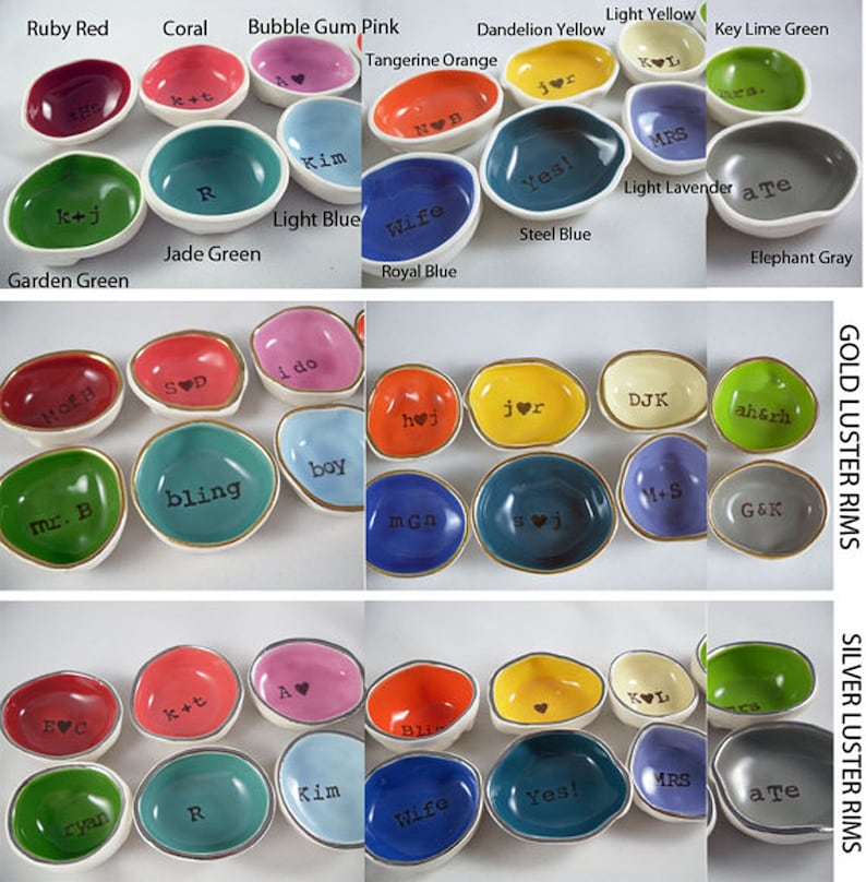 May include: A collection of small, irregularly shaped ceramic ring dishes in various colors, including red, pink, yellow, and blue. Each dish has a white interior and a gold or silver luster rim, with text such as initials or words like "Yes!" or "Bling".