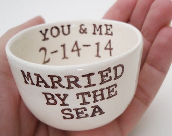 May include: White ceramic bowl with brown lettering that reads "You & Me 2-14-14 Married By The Sea".