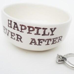 May include: White ceramic ring dish with the words "Happily Ever After" in brown lettering.