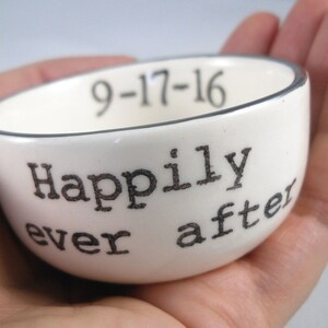 May include: White ceramic ring dish with a black rim and the text "Happily ever after" and the date "9-17-16" printed on the side.