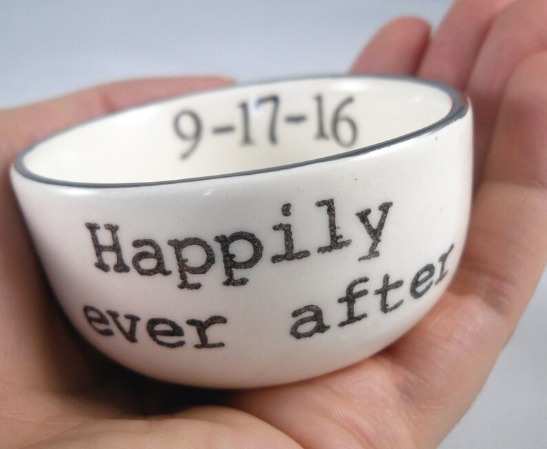 May include: White ceramic ring dish with a black rim and the text "Happily ever after" and the date "9-17-16" printed on the side.