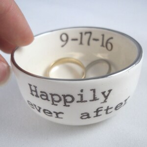 May include: White ceramic ring dish with a silver rim. The dish has the text "Happily ever after" and the date "9-17-16" printed on it.