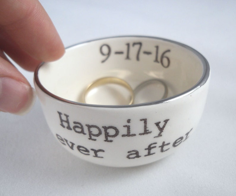 May include: White ceramic ring dish with a silver rim. The dish has the text "Happily ever after" and the date "9-17-16" printed on it.