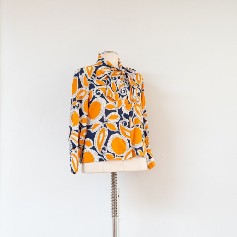 ML 1970s orange and blue abstract blouse 70s vintage pussy bow draped button-front rayon shirt with abstract floral print