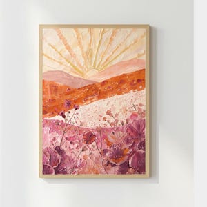 Op de afbeelding: Abstract landschapsschilderij in een houten lijst. Het kunstwerk toont een zonsopgang met stralend licht, bergen en een bloemenveld. Het kleurenpalet omvat tinten oranje, roze en wit.