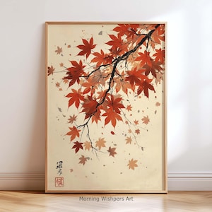 Puede incluir: Una impresión enmarcada que presenta una ilustración de estilo japonés de una rama de arce con hojas rojas vibrantes. La obra de arte incluye hojas cayendo y caracteres japoneses, sobre un fondo crema.
