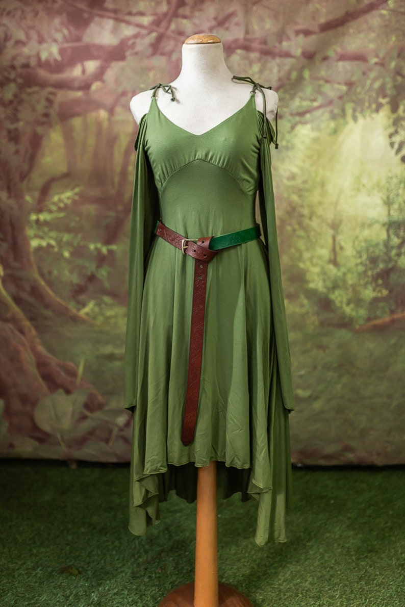 May include: A green dress with a low neckline and a brown leather belt. The dress has a high-low hemline and is made of a soft, flowing fabric.