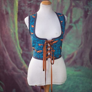 May include: A blue and orange patterned corset with brown laces. The corset is on a white mannequin.