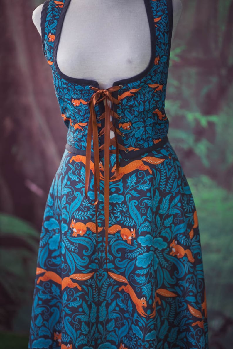 May include: A blue and orange dress with a floral pattern and squirrels. The dress has a brown lace-up bodice and a full skirt.