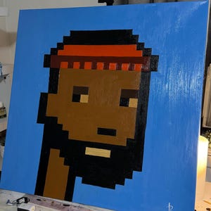 May include: A square canvas painting featuring a pixelated portrait of a person with brown skin, a black beard, and a red headband against a blue background. The artwork is signed in the bottom right corner.