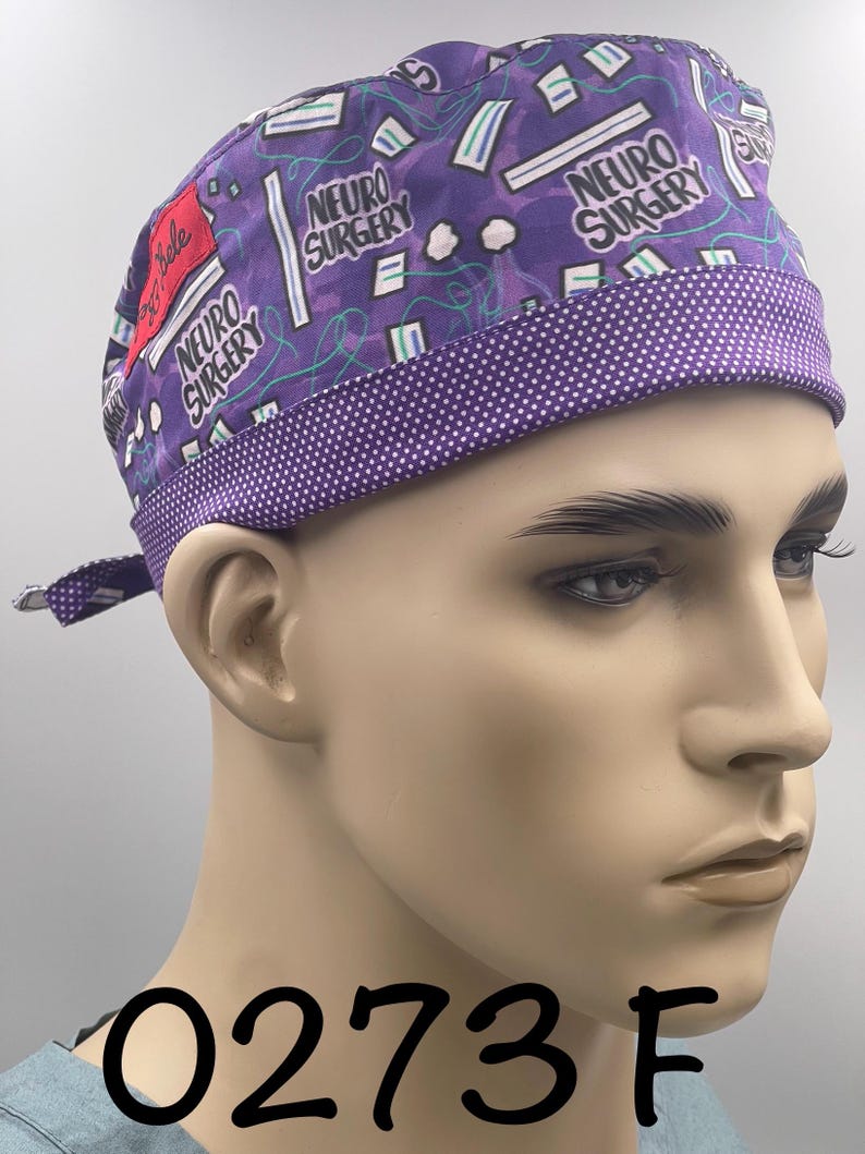 Puede incluir: Un gorro quir&uacute;rgico morado con un ribete de lunares blancos y las palabras "NEURO SURGERY" impresas. El gorro tiene un patr&oacute;n de gr&aacute;ficos de tem&aacute;tica m&eacute;dica y el n&uacute;mero "0273 F" est&aacute; impreso en la parte inferior.