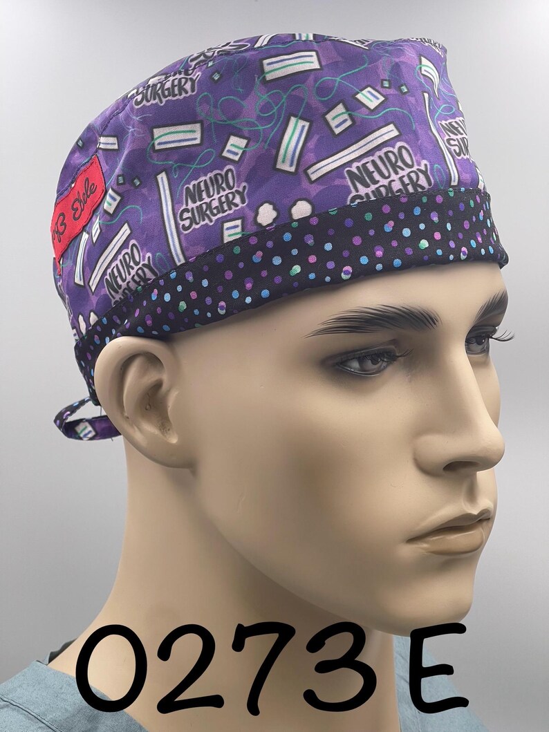 Puede incluir: Un gorro quir&uacute;rgico morado con ribete de lunares negros. El gorro presenta las palabras "NEURO SURGERY" y un patr&oacute;n de mascarillas m&eacute;dicas y l&iacute;neas onduladas. Una etiqueta roja dice "13 Style".