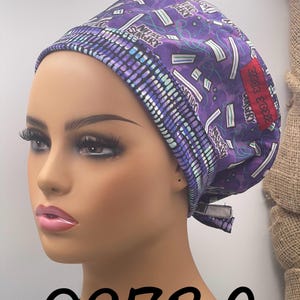 Puede incluir: Un gorro quir&uacute;rgico morado con un patr&oacute;n repetido de gr&aacute;ficos de tem&aacute;tica m&eacute;dica y las palabras "NEURO SURGERY". El gorro tiene un borde contrastante y un parche rojo con texto. El n&uacute;mero "0273C" est&aacute; impreso en la parte inferior.