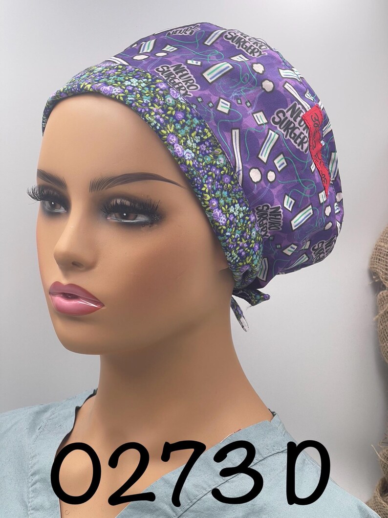 Puede incluir: Un gorro quir&uacute;rgico morado con las palabras "Neuro Surgeon" y gr&aacute;ficos de tem&aacute;tica m&eacute;dica. El gorro tiene un borde con estampado floral y un acento rojo. El n&uacute;mero "0273D" est&aacute; impreso en negro en la parte inferior.