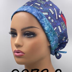 Puede incluir: Un gorro quir&uacute;rgico azul con un patr&oacute;n de formas blancas y verdes y las palabras "NEURO SURGERY". El gorro tiene un borde azul contrastante y est&aacute; atado en la parte posterior. El n&uacute;mero "0273 G" est&aacute; impreso en la parte inferior.