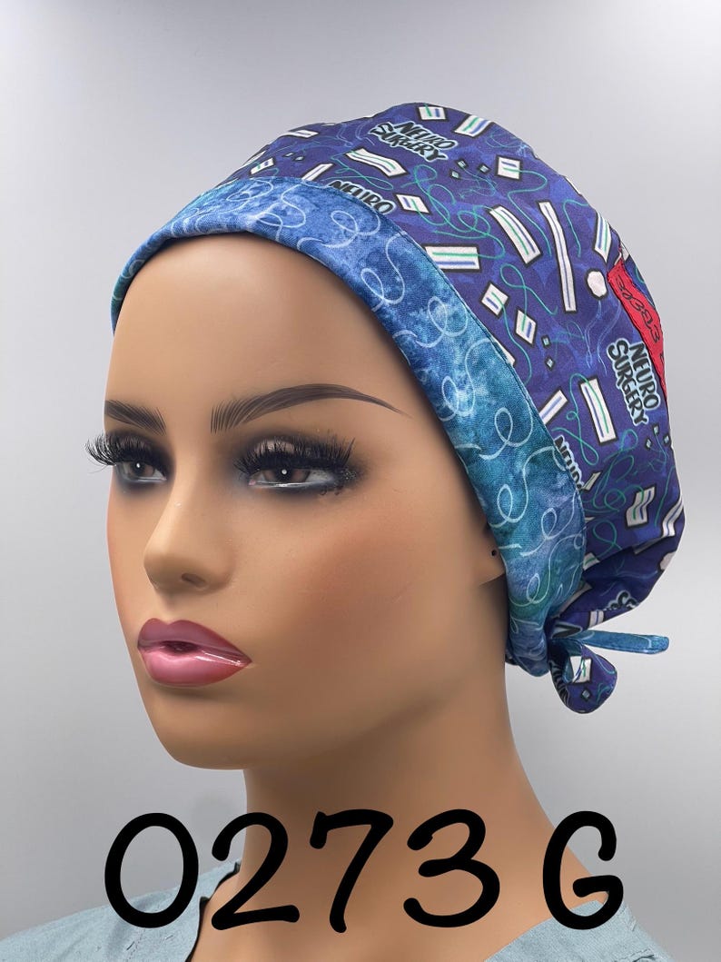 Puede incluir: Un gorro quir&uacute;rgico azul con un patr&oacute;n de formas blancas y verdes y las palabras "NEURO SURGERY". El gorro tiene un borde azul contrastante y est&aacute; atado en la parte posterior. El n&uacute;mero "0273 G" est&aacute; impreso en la parte inferior.