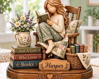 Könnte beinhalten: Eine Figur eines Mädchens mit langem Haar, das in einem Holzstuhl sitzt und ein Buch liest. Der Sockel zeigt den Namen Harper und ein Herz. Ein Stapel Bücher mit der Aufschrift Just A Girl Who Loves Books steht neben einem Blumenkrug.