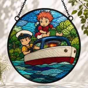 Può includere: Un acchiappasole circolare in vetro colorato che raffigura due personaggi animati su una piccola barca in acqua blu. Un personaggio indossa un cappello da marinaio bianco e una maglietta gialla, l'altro ha capelli arancioni e un vestito rosso. Alberi.